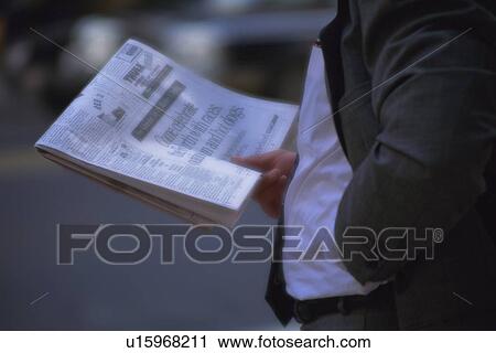 Businessman holding newspapers, side view, New York City, NY, USA View Large Photo Image Stock Image - Businessman holding newspapers, side view, New York City, NY, USA. Fotosearch
