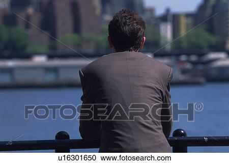 Businessman leaning on railing and looking at river, rear view, New York City, NY, USA View Large Photo Image Stock Image - Businessman leaning on railing and looking at river, rear view, New York City, NY, USA. Fotosearch