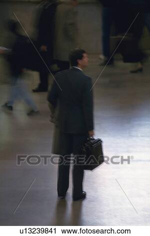 Businessman standing and holding a bag, high angle view, blurred motion, New York City, NY, USA View Large Photo Image Stock Image - Businessman standing and holding a bag, high angle view, blurred motion, New York City, NY, USA. Fotosearch