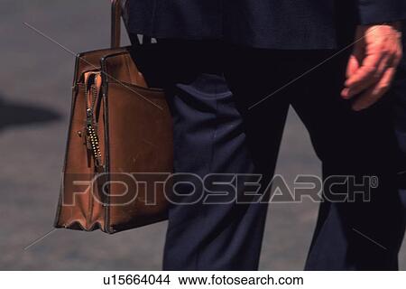 Businessman walking and holding a bag, close up, New York City, NY, USA View Large Photo Image Picture - Businessman walking and holding a bag, close up, New York City, NY, USA. Fotosearch
