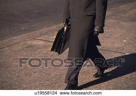 Businessman walking and holding a bag, high angle view, New York City, NY, USA View Large Photo Image Picture - Businessman walking and holding a bag, high angle view, New York City, NY, USA. Fotosearch