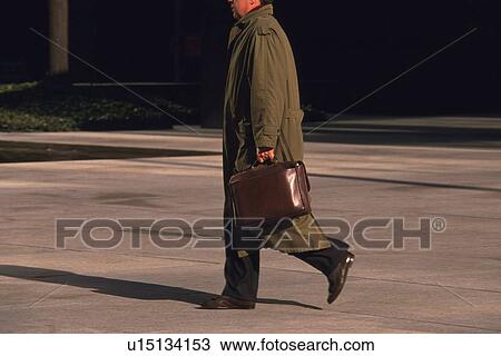 Businessman walking and holding a bag, side view, New York City, NY, USA View Large Photo Image Stock Image - Businessman walking and holding a bag, side view, New York City, NY, USA. Fotosearch