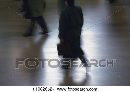 Stock Photo - Businessman walking and holding a bag, high angle view, blurred motion, New York City, NY, USA. Fotosearch