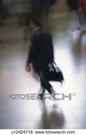 Businessman walking and holding a bag, high angle view, blurred motion, New York City, NY, USA View Large Photo Image Stock Photo - Businessman walking and holding a bag, high angle view, blurred motion, New York City, NY, USA. Fotosearch