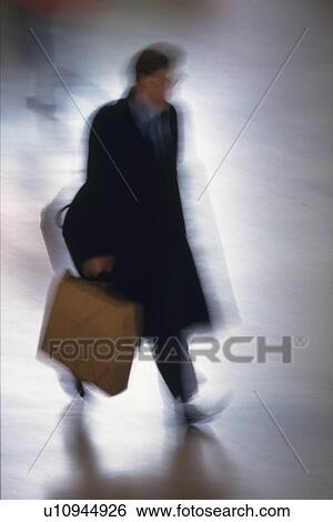 Stock Photograph - Businessman walking and holding a bag, high angle view, blurred motion, New York City, NY, USA. Fotosearch