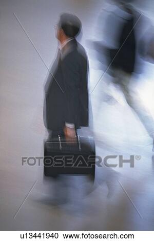 Businessman walking and holding a briefcase, high angle view, blurred motion, New York City, NY, USA View Large Photo Image Stock Image - Businessman walking and holding a briefcase, high angle view, blurred motion, New York City, NY, USA. Fotosearch