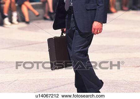 Businessman walking and holding a briefcase, side view, New York City, NY, USA View Large Photo Image Stock Image - Businessman walking and holding a briefcase, side view, New York City, NY, USA. Fotosearch