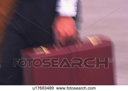 Businessman walking and holding a briefcase, close up, blurred motion, New York City, NY, USA View Large Photo Image Stock Photo - Businessman walking and holding a briefcase, close up, blurred motion, New York City, NY, USA. Fotosearch