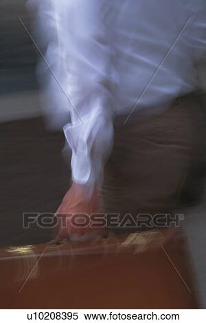 Businessman walking and holding a briefcase, close up, blurred motion, New York City, NY, USA View Large Photo Image Stock Photography - Businessman walking and holding a briefcase, close up, blurred motion, New York City, NY, USA. Fotosearch