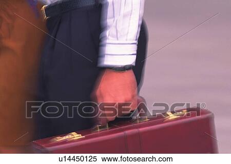 Stock Photography - Businessman walking and holding a briefcase, close up, blurred motion, New York City, NY, USA. Fotosearch