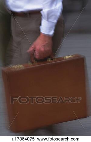 Stock Photography - Businessman walking and holding a briefcase, close up, blurred motion, New York City, NY, USA. Fotosearch
