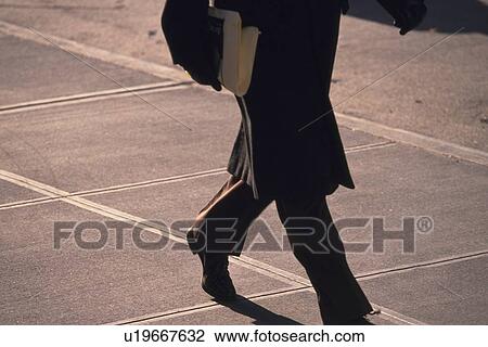 Businessman walking and holding newspaper, side view, New York City, NY, USA View Large Photo Image Stock Image - Businessman walking and holding newspaper, side view, New York City, NY, USA. Fotosearch