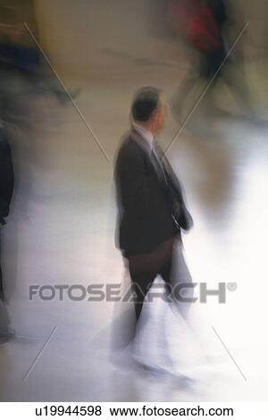Businessman walking and looking away, high angle view, blurred motion, New York City, NY, USA View Large Photo Image Stock Photo - Businessman walking and looking away, high angle view, blurred motion, New York City, NY, USA. Fotosearch