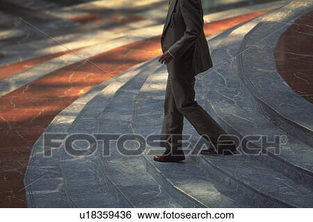 Businessman walking down stairs, side view, New York City, NY, USA View Large Photo Image Stock Photograph - Businessman walking down stairs, side view, New York City, NY, USA. Fotosearch