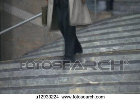 Picture - Businessman walking down the stairs, low angle view, blurred motion, New York City, NY, USA. Fotosearch