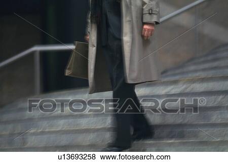 Stock Photo - Businessman walking down the stairs, low angle view, New York City, NY, USA. Fotosearch