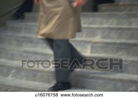 Businessman walking down the stairs, high angle view, blurred motion, New York City, NY, USA View Large Photo Image Stock Photo - Businessman walking down the stairs, high angle view, blurred motion, New York City, NY, USA. Fotosearch
