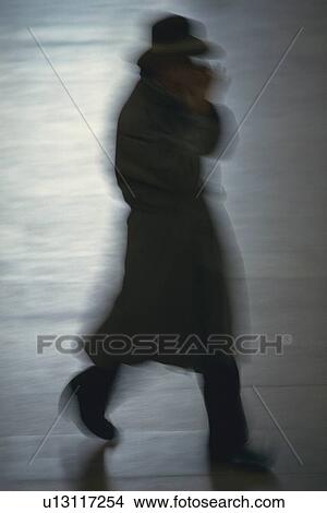 Picture - Man in overcoat walking down the street, side view, blurred motion, New York City, NY, USA. Fotosearch
