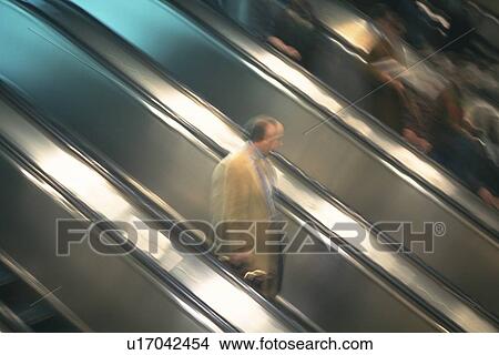 Picture - People riding escalators, high angle view, blurred motion, New York City, NY, USA. Fotosearch