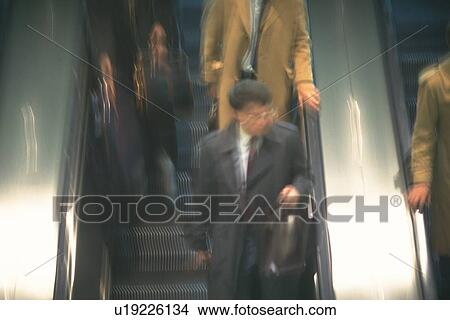 Picture - People riding escalators, high angle view, blurred motion, New York City, NY, USA. Fotosearch