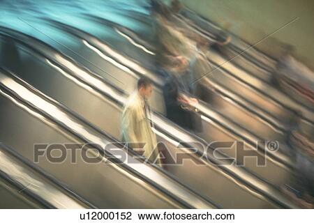 People riding escalators, high angle view, blurred motion, New York City, NY, USA View Large Photo Image Stock Image - People riding escalators, high angle view, blurred motion, New York City, NY, USA. Fotosearch