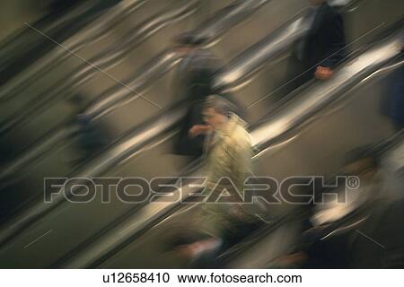 People riding escalators, high angle view, blurred motion, New York City, NY, USA View Large Photo Image Stock Image - People riding escalators, high angle view, blurred motion, New York City, NY, USA. Fotosearch