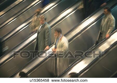 Stock Photo - People riding escalators, high angle view, blurred motion, New York City, NY, USA. Fotosearch