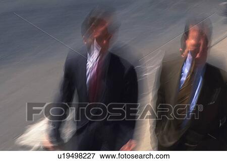 Stock Photo - Two men walking side by side, high angle view, blurred motion, New York City, NY, USA. Fotosearch