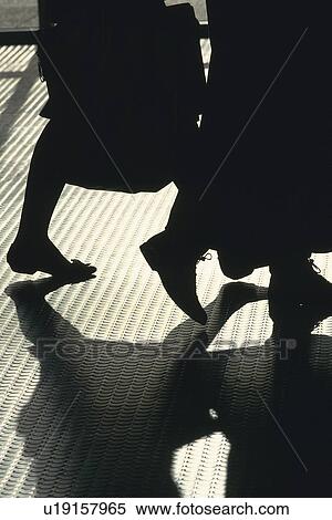 Stock Photography - Two people walking on metal floor, high angle view, New York City, NY, USA. Fotosearch