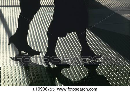 Stock Photography - Two women walking on metal floor, high angle view, New York City, NY, USA. Fotosearch