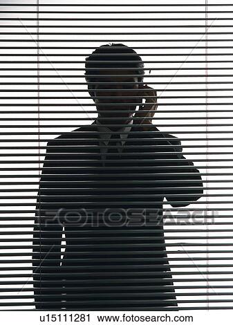 Businessman behind blind, using a mobile phone, front view View Large Photo Image Stock Image - Businessman behind blind, using a mobile phone, front view. Fotosearch