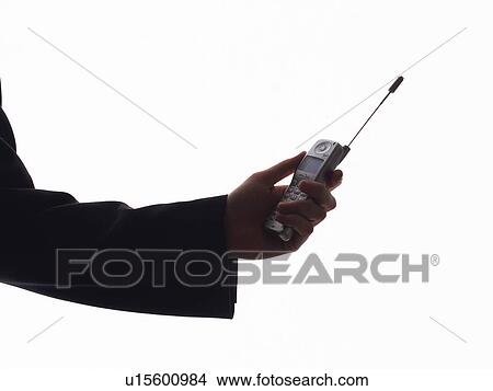 Picture - Businessman holding a mobile phone, side view. Fotosearch