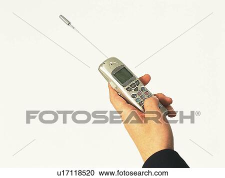 Stock Image - Businessman holding a mobile phone, high angle view. Fotosearch