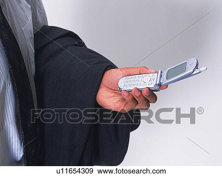Businessman holding a mobile phone, high angle view View Large Photo Image Stock Photo - Businessman holding a mobile phone, high angle view. Fotosearch