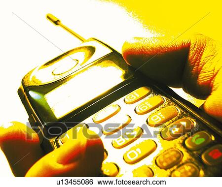 Stock Photograph - Businessman holding a mobile phone, close up, toned image. Fotosearch