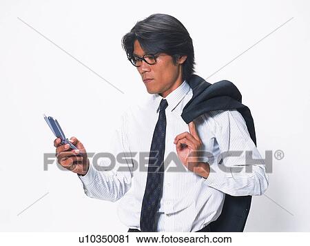 Businessman holding and looking at a mobile phone, jacket on his shoulder, side view View Large Photo Image Stock Image - Businessman holding and looking at a mobile phone, jacket on his shoulder, side view. Fotosearch
