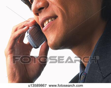 Businessman using a mobile phone, low angle view View Large Photo Image Stock Photo - Businessman using a mobile phone, low angle view. Fotosearch