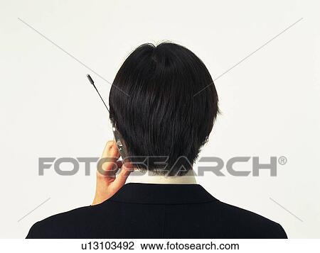 Businessman using a mobile phone, rear view View Large Photo Image Stock Image - Businessman using a mobile phone, rear view. Fotosearch
