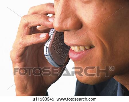 Stock Photography - Businessman using a mobile phone, side view, close up. Fotosearch