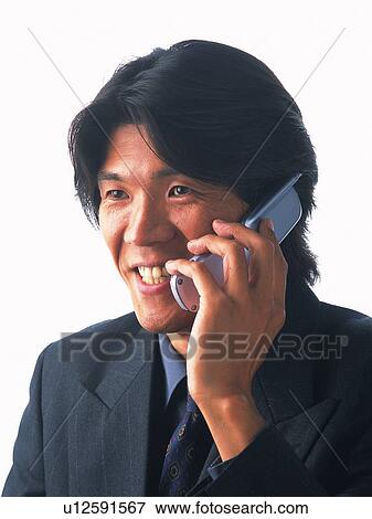 Businessman using a mobile phone, smiling, front view View Large Photo Image Stock Photo - Businessman using a mobile phone, smiling, front view. Fotosearch