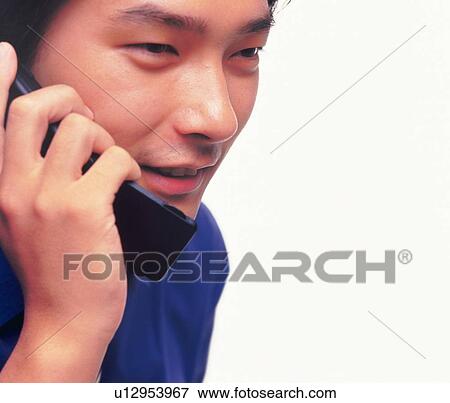 Stock Photo - Businessman using a mobile phone, smiling, close up. Fotosearch