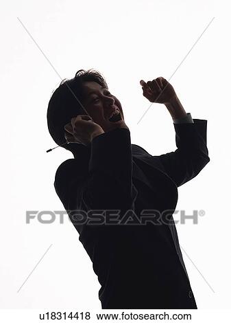 Stock Photo - Businessman using a mobile phone, rejoicing, side view. Fotosearch