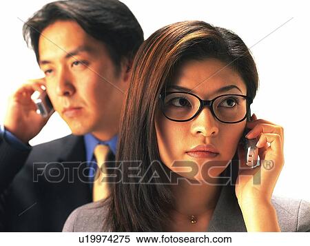 Stock Photography - Man and woman using mobile phone, woman wearing glasses. Fotosearch