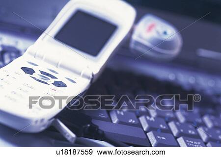 Mobile phone being connected to laptop, high angle view, close up, soft focus View Large Photo Image Stock Photo - Mobile phone being connected to laptop, high angle view, close up, soft focus. Fotosearch