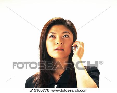 Stock Photograph - Woman using a mobile phone, looking up, front view. Fotosearch