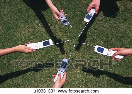 Five People Holding a Mobile Phone, High Angle View View Large Photo Image Stock Photo - Five People Holding a Mobile Phone, High Angle View. Fotosearch