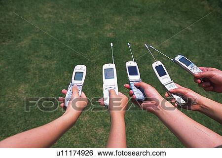 Stock Photograph - Five People Holding a Mobile Phone, High Angle View. Fotosearch
