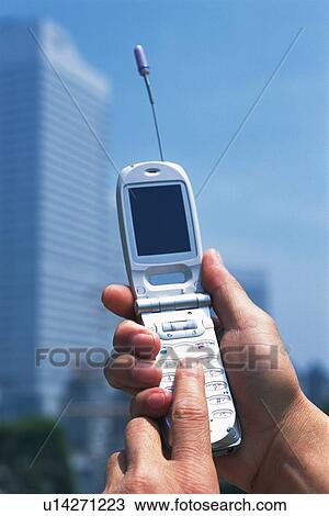 Stock Image - Holding a Mobile Phone, Front View. Fotosearch