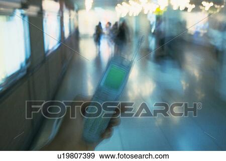 Holding a Mobile Phone, High Angle View, Blurred Motion View Large Photo Image Stock Photo - Holding a Mobile Phone, High Angle View, Blurred Motion. Fotosearch