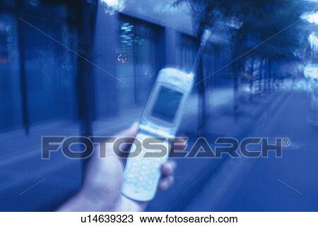 Stock Image - Holding a Mobile Phone, High Angle View. Fotosearch